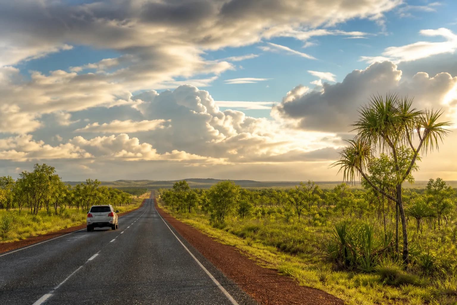 A rental SUV travelling along a sealed tropical highway in Australia's Top End