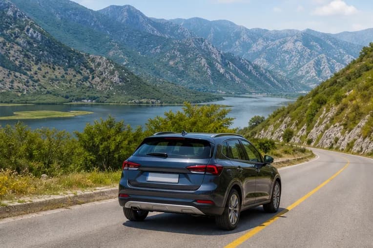 A rental car on an open road beneath Montenegro's rugged mountains near Podgorica