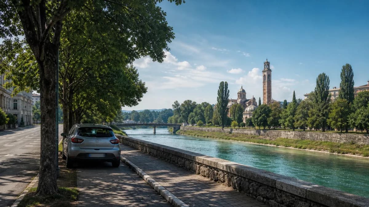 Compact rental car beside the Vrbas river and leafy city road in Banja Luka