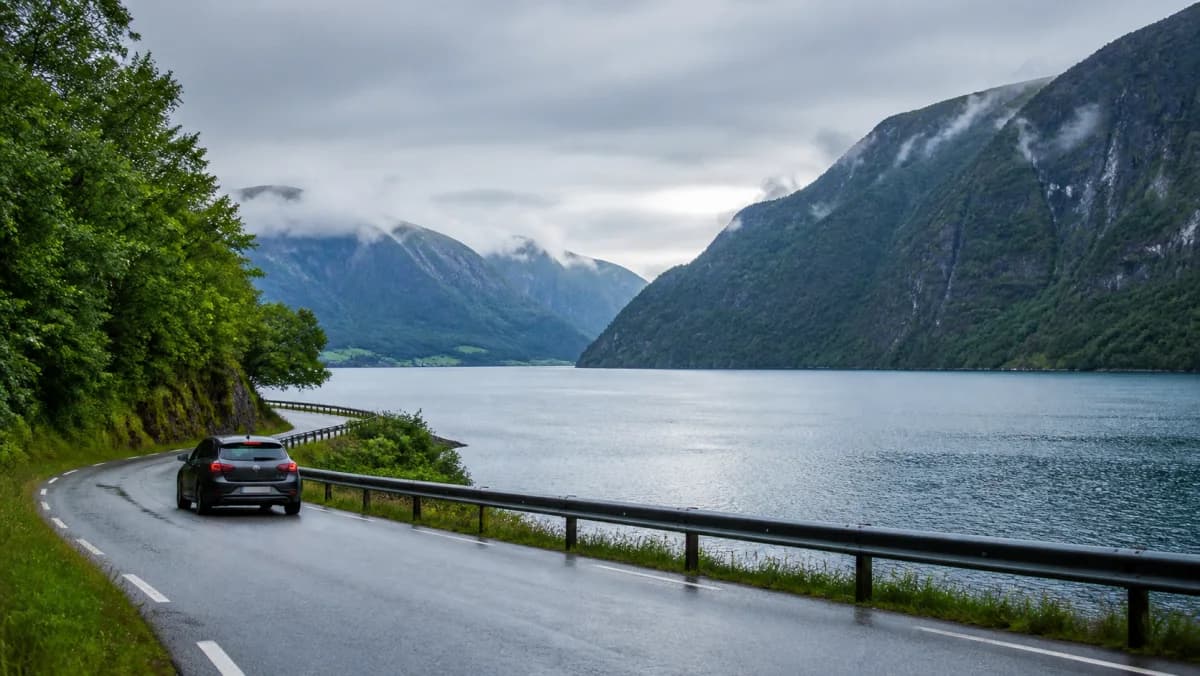 Rental car beside a fjord road among steep mountains near Bergen, Norway