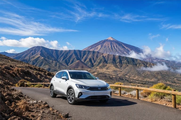 Rental car on a volcanic road with Mount Teide rising above Tenerife